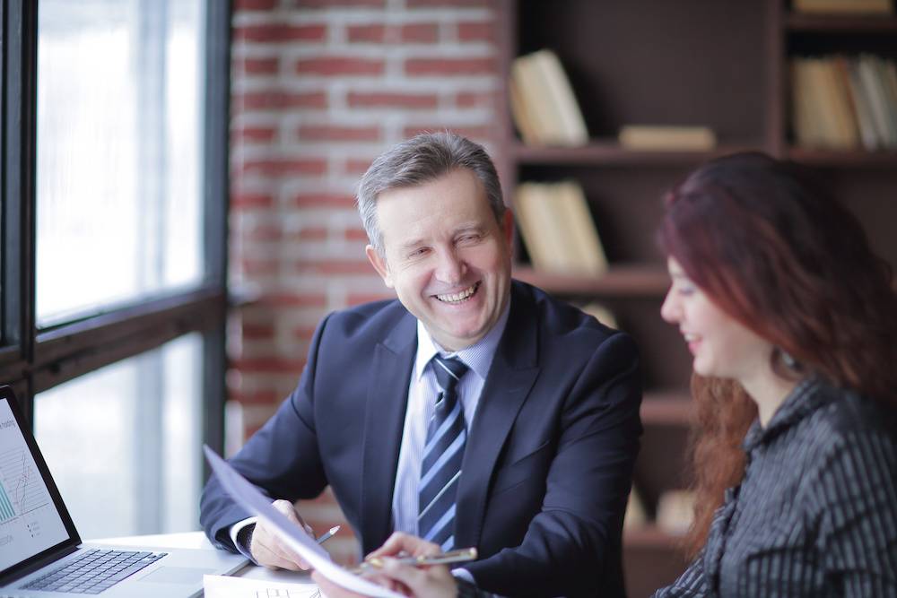 Employee performance review, man in suit and woman in button down shirt.