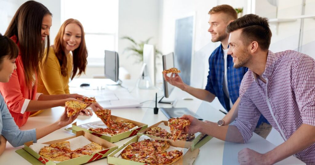 Workplace team sharing pizza — employee engagement goes beyond perks